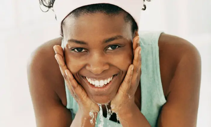 black woman washing her face