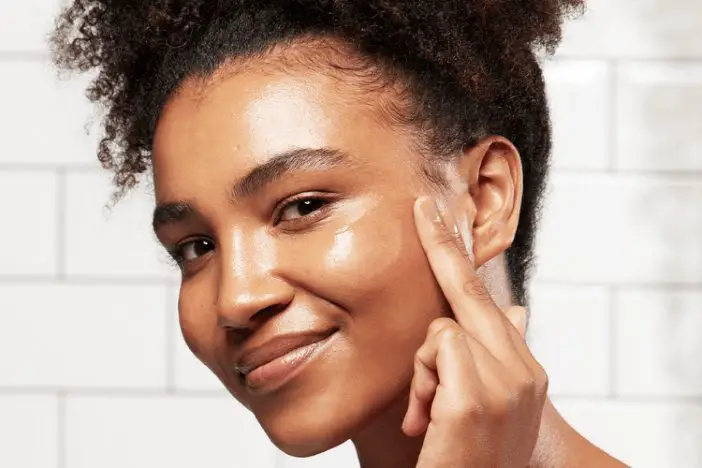 woman applying face serum